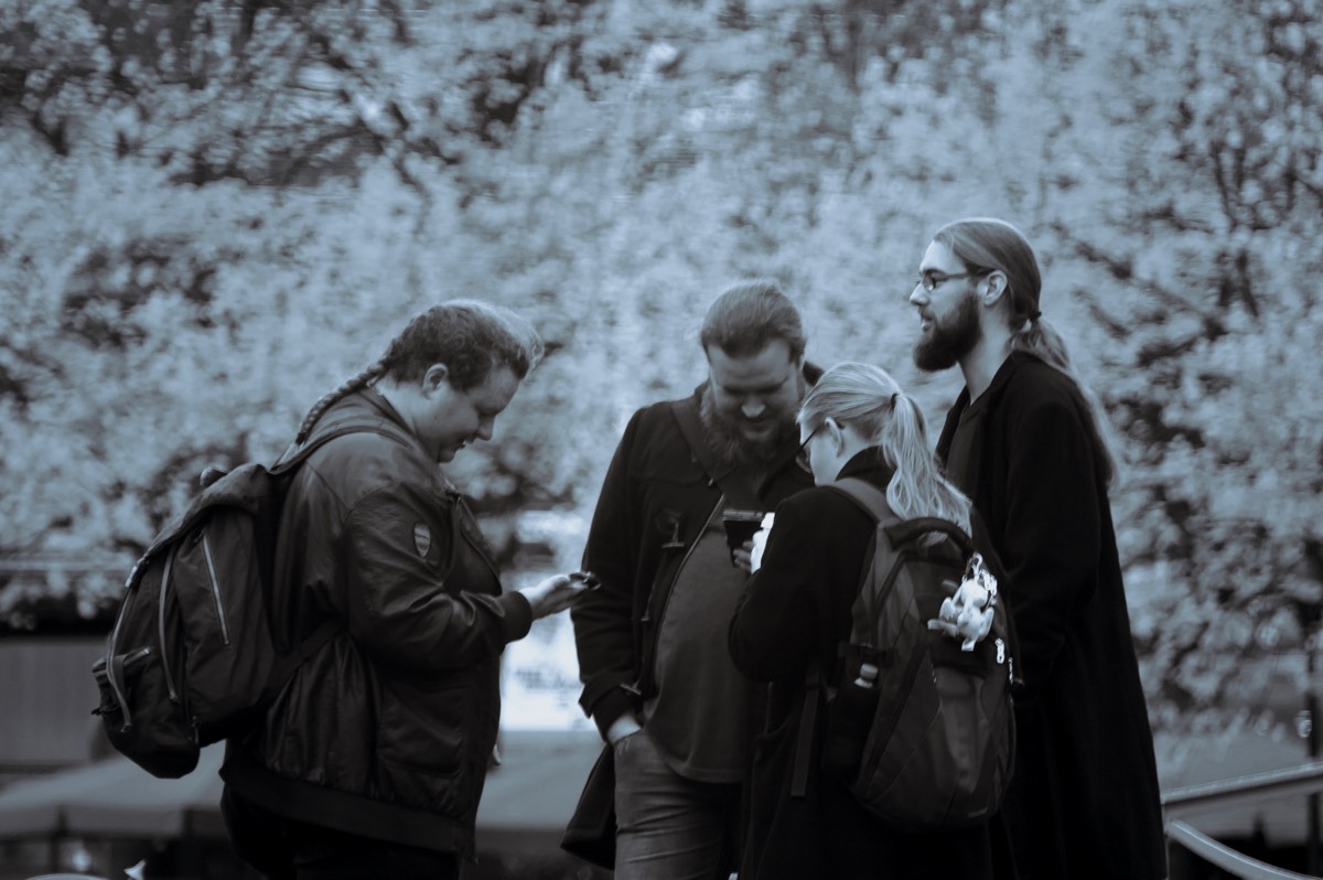 Young folks standing around and looking at their phones in Leeuwarden