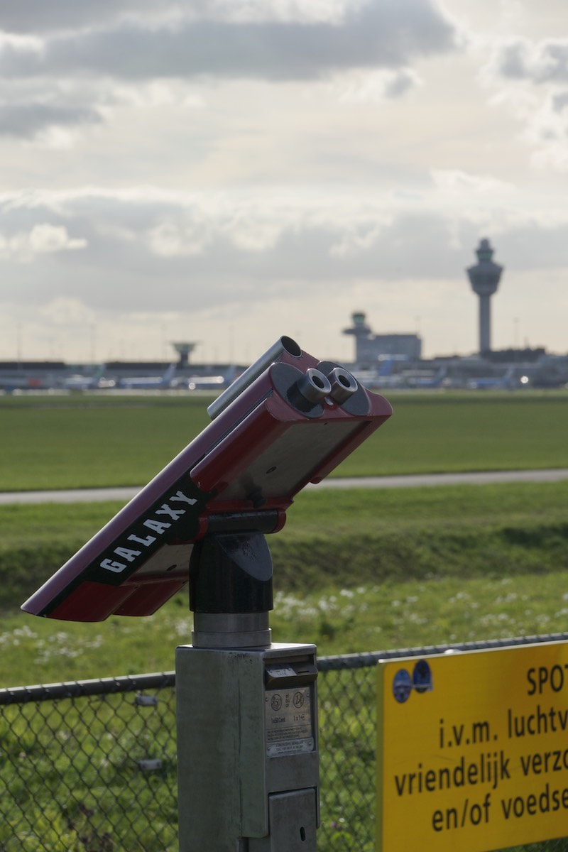 Binoculars for plane spotting, with Schiphol air control tower in the background