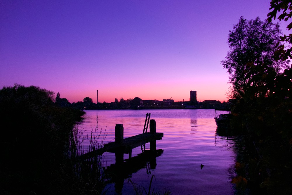 View of the Zaan river at sunset, with a small jetty in the foreground